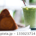 Iced matcha drink and croissant on table at cafe 133023714