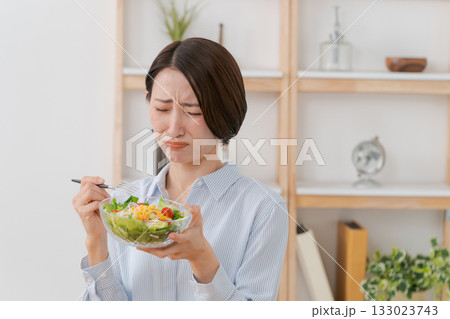 サラダを食べて顔をしかめる女性 サラダを食べて顔をしかめる女性 133023743