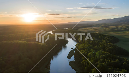 Aerial view of a winding river at sunset with lush green forest 133024708