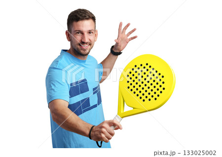 Man smiles while holding a yellow paddle racket ready for a game indoors 133025002