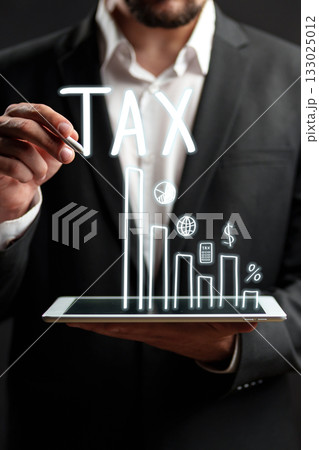 Businessman presenting tax data on a digital tablet with graphs and symbols Businessman presenting tax data on a digital tablet with graphs and symbols 133025012