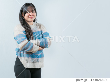 Attractive young Asian woman with arms crossed isolated. Portrait of beautiful and smiling Asian woman on white background 133026827