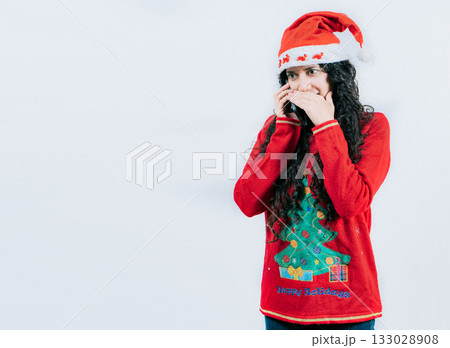 Girl in Christmas hat talking on the phone secretly. Woman in Christmas sweater secretly calling by phone Girl in Christmas hat talking on the phone secretly. Woman in Christmas sweater secretly calling by phone 133028908