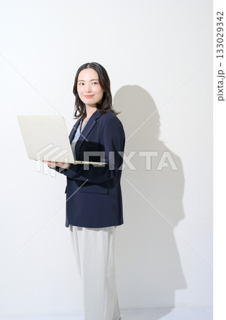 白背景でパソコンを持つ日本人女性 133029342