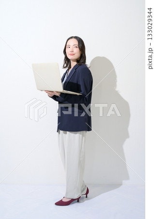 白背景でパソコンを持つ日本人女性 133029344