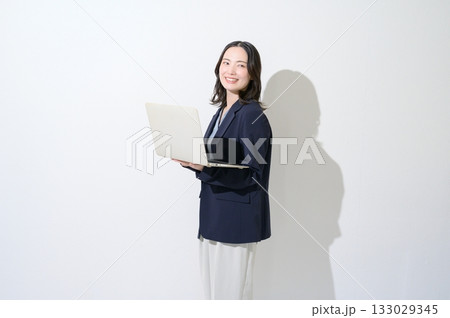 白背景でパソコンを持つ日本人女性 133029345