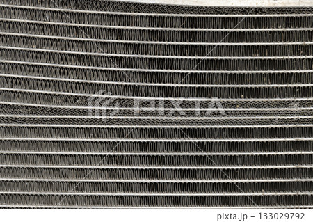 metal radiator parts of a car damaged after an accident on the road, part of the radiator of the car cooling system 133029792