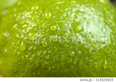 wet green ripe citrus limes on the wooden table in the kitchen, ripe and juicy lime fruits for cooking, green limes covered with drops of water wet green ripe citrus limes on the wooden table in the kitchen, ripe and juicy lime fruits for cooking, green limes covered with drops of water 133029819