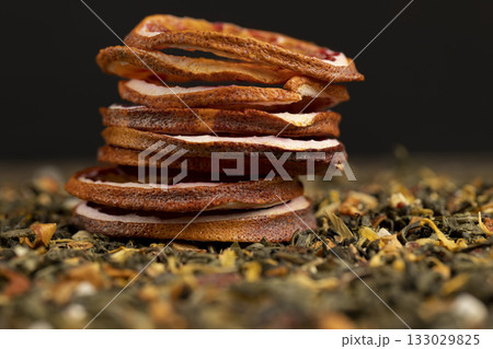 high-quality green tea with added flavors and pieces of fruit and cut dried red oranges, bright large dry slices of blood red orange and tea with pieces of fruit 133029825
