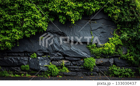 The surface contrasts with the rough pattern of the old black stone wall.The surface contrasts with the rough pattern of the old black stone wall. 133030437