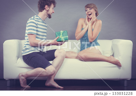 Young man giving woman gift box Young man giving woman gift box 133031228