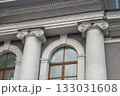 Facade fragment of an old classicism style building with Ionic columns and an arched window. Architectural background symbolizing justice, government, education, or culture and finance. 133031608