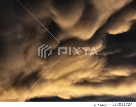 Storm clouds on sunset. Light in the dark and dramatic storm clouds. Background of storm clouds before a thunderstorm. Mammatus clouds Storm clouds on sunset. Light in the dark and dramatic storm clouds. Background of storm clouds before a thunderstorm. Mammatus clouds 133031724