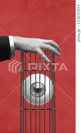 Contemporary collage of hand holding cage with trapped eye inside on red background. 133032854