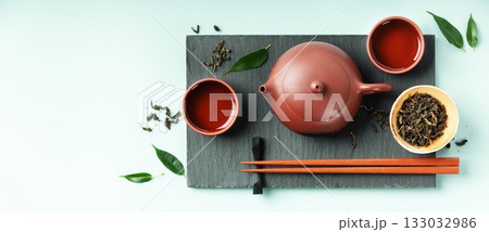 Asian Tea Ceremony Banner with Red Clay Teapot and Green Leaves 133032986