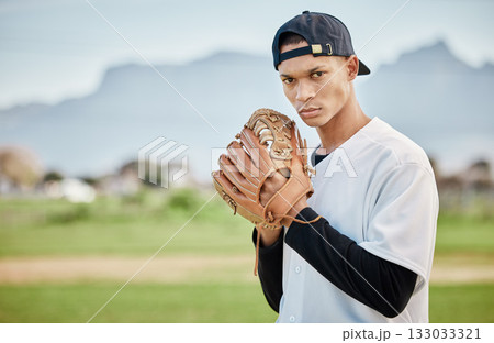Portrait pitcher, baseball player or man training for a sports game on outdoor field stadium. Fitness, motivation or focused athlete pitching or throwing a ball with a glove in workout or exercise 133033321