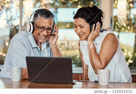 Laptop, headphones and senior couple on video call in home, chatting and talking. Technology, computer and happy, elderly and retired man and woman in virtual conversation or online streaming 133033352