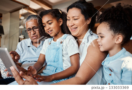 Family, relax and girl with tablet in home living room for social media, video streaming or web browsing. Technology, smile or care of happy grandfather, grandma and children bonding with touchscreen Family, relax and girl with tablet in home living room for social media, video streaming or web browsing. Technology, smile or care of happy grandfather, grandma and children bonding with touchscreen 133033369