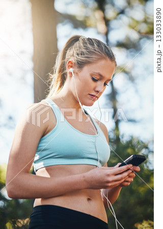 Woman with earphones, smartphone and fitness with music outdoor, listening for motivation on run in park. Female runner with song choice, podcast or radio streaming with exercise, focus and health Woman with earphones, smartphone and fitness with music outdoor, listening for motivation on run in park. Female runner with song choice, podcast or radio streaming with exercise, focus and health 133033890