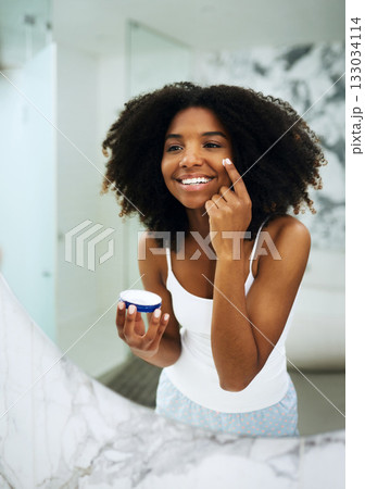 Skin care, happiness and black woman in bathroom mirror with cream, smile and morning dermatology routine. Health, wellness and luxury skincare at home, girl in reflection and lotion on face for glow Skin care, happiness and black woman in bathroom mirror with cream, smile and morning dermatology routine. Health, wellness and luxury skincare at home, girl in reflection and lotion on face for glow 133034114