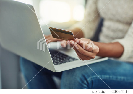 Laptop, credit card and woman online shopping with payment on the internet on her home living room sofa. Ecommerce, computer and hands of person doing website payment on an app, connection or web 133034132