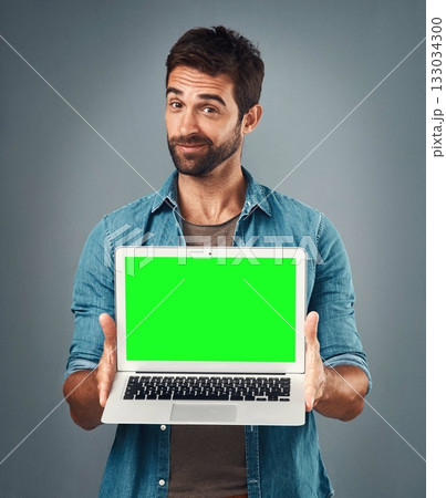 Man, laptop and portrait with mockup green screen for advertising or marketing against a grey studio background. Male person showing computer display, chromakey or mock up space for advertisement Man, laptop and portrait with mockup green screen for advertising or marketing against a grey studio background. Male person showing computer display, chromakey or mock up space for advertisement 133034300