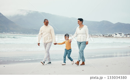 Grandfather, grandma and child walking on beach enjoying holiday, travel vacation and weekend together. Big family, nature and happy grandparents holding hands for bonding, quality time and relax Grandfather, grandma and child walking on beach enjoying holiday, travel vacation and weekend together. Big family, nature and happy grandparents holding hands for bonding, quality time and relax 133034380