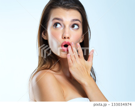 Wow, hand and woman surprised, shocked and omg expression for skincare results on blue background. Face, wtf and girl model with open mouth emoji for makeup, glamour and luxury cosmetic isolated 133034974