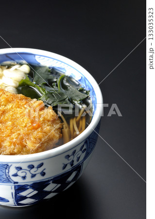 コロッケが乗ってるかけそばを黒背景で撮影 133035323