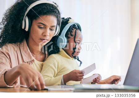 Headphones, elearning and girl with mother and homework flash cards for study in a home. Online learning, digital kids app and computer of a child with a mom helping with school reading in a house 133035356