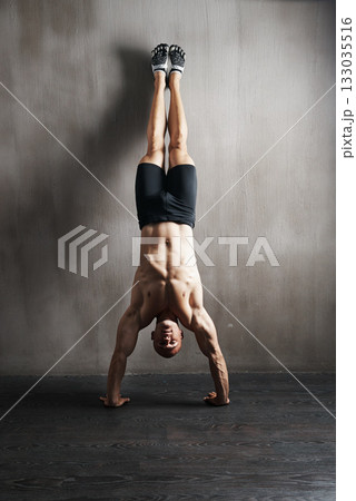 Fitness body, wall and man doing handstand for muscle workout, balance focus or health club exercise. Gym training, hand stand and strong person, athlete or sportsman doing push up challenge 133035516