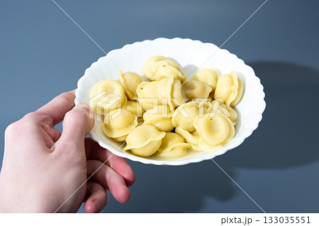 Dumplings in White Plate on Blue Background Dumplings in White Plate on Blue Background 133035551