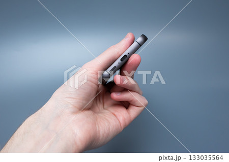 Modern smartphone with triple camera in hand on blue background for advertising Modern smartphone with triple camera in hand on blue background for advertising 133035564