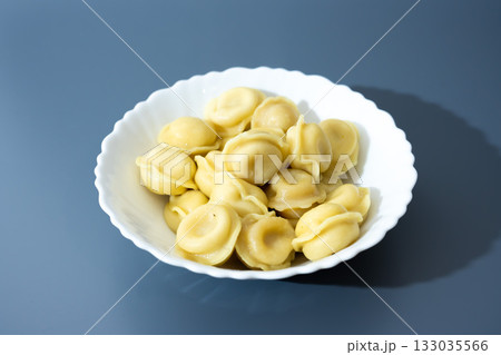 Dumplings in White Plate on Blue Background Dumplings in White Plate on Blue Background 133035566