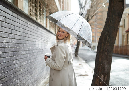 Umbrella, city street portrait and woman in rain with happiness on a sidewalk from winter weather. Happy female person, raining and travel on a urban road outdoor in New York on holiday with joy 133035909
