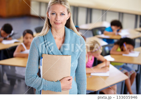 Teacher, portrait and woman with binder in classroom, elementary school or class. Education, teaching and female educator with folder, paperwork or documents for serious learning, knowledge or study. Teacher, portrait and woman with binder in classroom, elementary school or class. Education, teaching and female educator with folder, paperwork or documents for serious learning, knowledge or study. 133035946