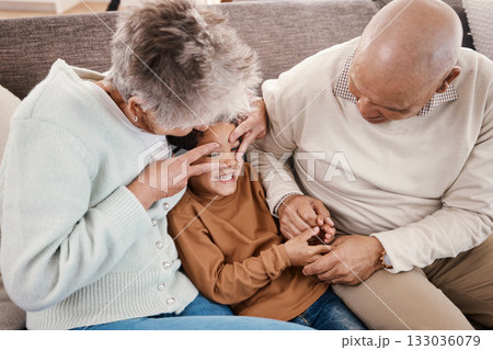 Love, grandparents and boy on couch, playing and quality time for happiness, carefree and bonding. Granny, grandfather or grandchild on sofa, loving together or relax on break, happy or kid in lounge 133036079