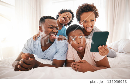 Selfie, funny and black family on the bed with a tablet for communication, memory and comedy. Crazy, comic and African children taking a photo on tech with parents for bonding and quality time 133036958