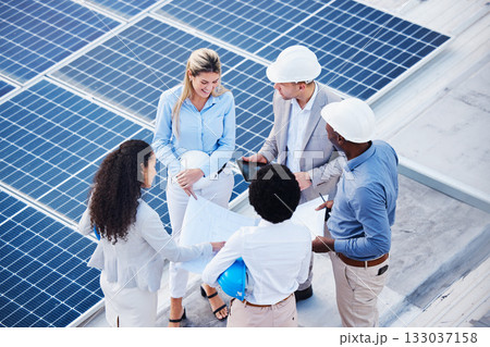 Solar and renewable energy, blueprint or engineering team on roof building electricity technology for sustainability. Collaboration, top view or black man talking or planning a project with people 133037158