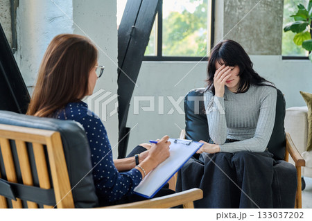 Sad stressed young woman patient talking with female psychologist, mental counselor 133037202