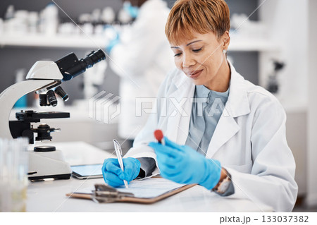 Scientist, woman and writing report with results, focus or analytics in pharma laboratory. Science expert, checklist or research with blood sample, medical innovation or study at pharmaceutical trial 133037382
