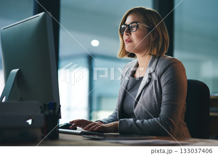 Computer, typing and business woman in office working late on project at night alone. Desktop, professional and female person writing email, report or planning, reading and overtime for deadline. Computer, typing and business woman in office working late on project at night alone. Desktop, professional and female person writing email, report or planning, reading and overtime for deadline. 133037406