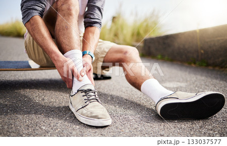 Fitness, athlete and man with ankle injury, pain or accident while skateboarding in the street. Sports, exercise and male skateboarder with muscle sprain, medical emergency or injured leg in the road 133037577