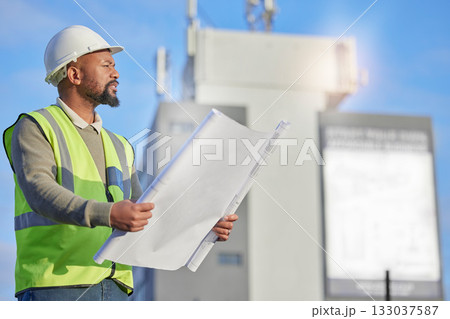 Engineering, blueprint and black man planning at construction site with paperwork. Handyman, outdoor and African male contractor working with architecture plans for building, repairs or maintenance. Engineering, blueprint and black man planning at construction site with paperwork. Handyman, outdoor and African male contractor working with architecture plans for building, repairs or maintenance. 133037587
