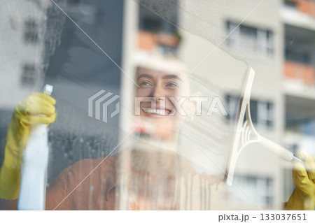 Window cleaning, smile and happy woman at home washing windows with glass cleaner. Helping, working and maid with spray detergent product for house chores and disinfectant wipe with sanitation soap 133037651