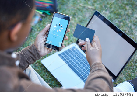 Credit card, phone banking app and loading on a mobile website payment with laptop mockup screen. Online shopping, ecommerce and 5g connectivity of a customer doing a internet sale outdoor on grass 133037688