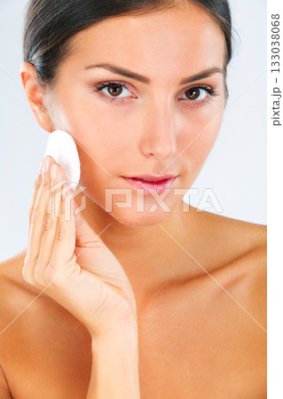 Skincare, portrait and female model with a cotton pad in studio for a beauty, natural and face routine. Health, wellness and woman with health, wellness or cosmetic facial product by white background 133038068