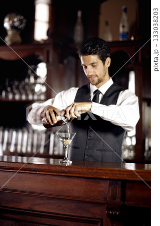 Bartender man, glass and mixing cocktail at bar for service, drink or hospitality at party, club or event. Male server, barman or waiter with alcohol, spirit or mixer for presentation at restaurant Bartender man, glass and mixing cocktail at bar for service, drink or hospitality at party, club or event. Male server, barman or waiter with alcohol, spirit or mixer for presentation at restaurant 133038203