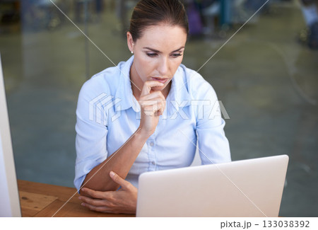 Business woman, thinking and focused at laptop to research ideas, brainstorming solution and online planning. Serious female worker at computer for insight, reading email and review tech information 133038392