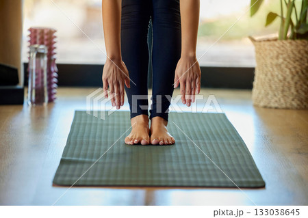 Hands, feet and yoga with a woman in her home for a mental health, fitness or wellness workout. Exercise, pilates or stretching and a female yogi training with a forward bend alone for zen Hands, feet and yoga with a woman in her home for a mental health, fitness or wellness workout. Exercise, pilates or stretching and a female yogi training with a forward bend alone for zen 133038645